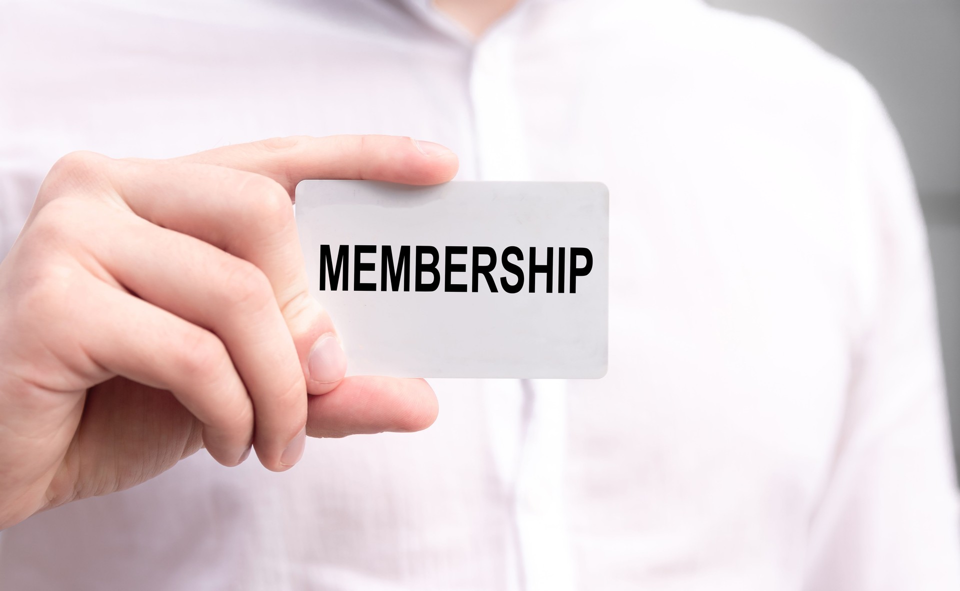 MEMBERSHIP text is written on the card that the businessman in white shirt hold in his hands. Business concept.